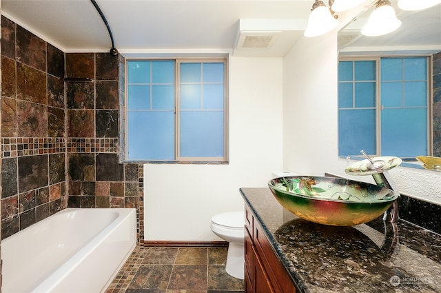 bathroom featuring tile walls, vanity, and toilet