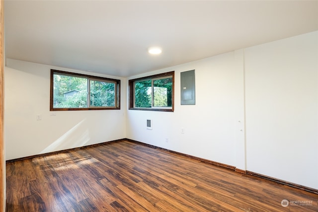 empty room featuring electric panel and hardwood / wood-style flooring