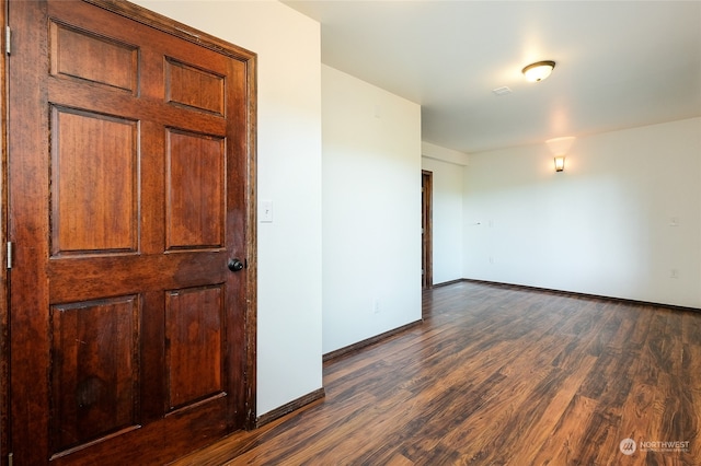 unfurnished room with dark hardwood / wood-style flooring