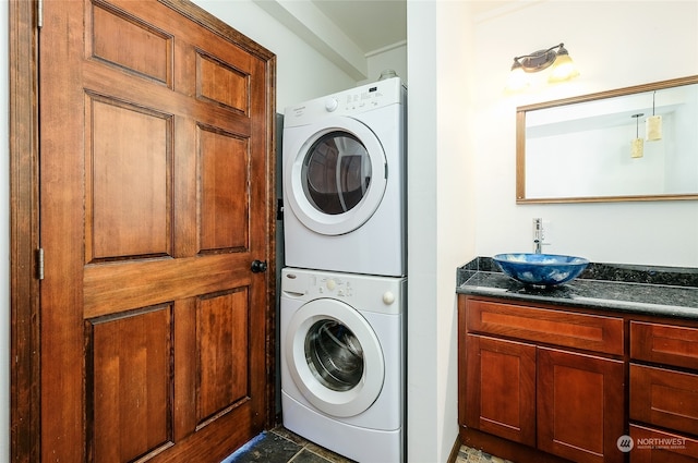 clothes washing area with stacked washer and dryer and sink