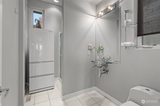 bathroom featuring tile patterned floors, toilet, and an enclosed shower