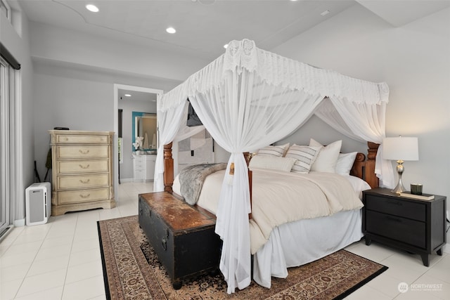 bedroom with light tile patterned floors and ensuite bathroom