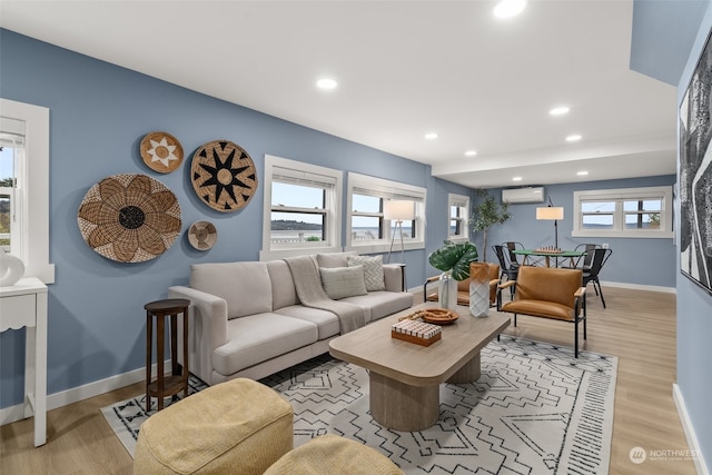 living room featuring light wood-type flooring and a wall mounted air conditioner