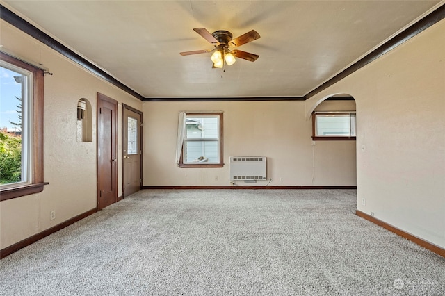 spare room with ornamental molding, light colored carpet, heating unit, and ceiling fan