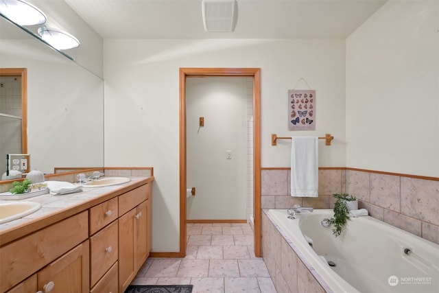 bathroom featuring vanity and tiled tub