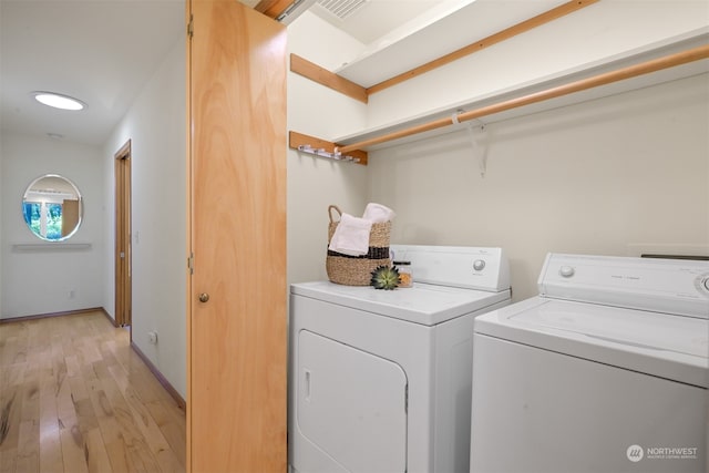 laundry room featuring washer and dryer and light hardwood / wood-style floors