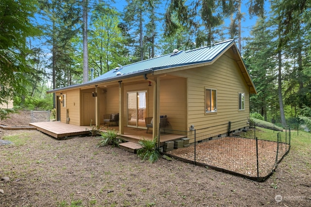 rear view of property featuring a wooden deck