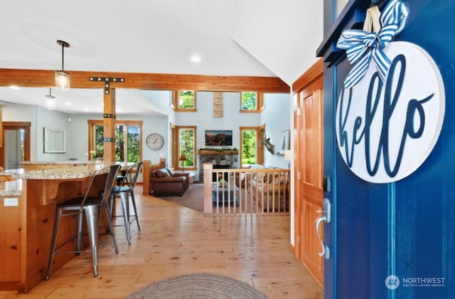 entrance foyer featuring recessed lighting, light wood-type flooring, and a stone fireplace