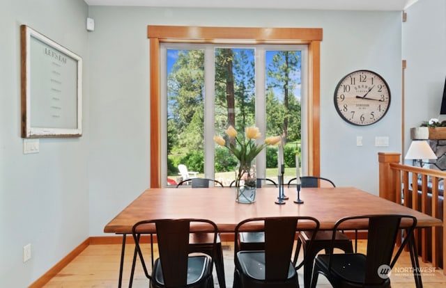 dining area with baseboards and light wood-type flooring