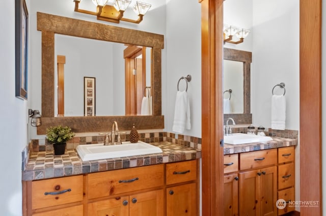 full bathroom featuring tasteful backsplash, two vanities, and a sink