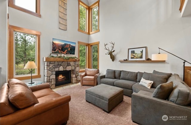 carpeted living area with a high ceiling and a fireplace