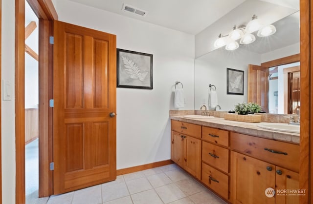 bathroom featuring a sink, visible vents, double vanity, and tile patterned flooring