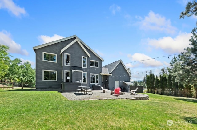 back of house featuring a patio, a lawn, a fire pit, and fence