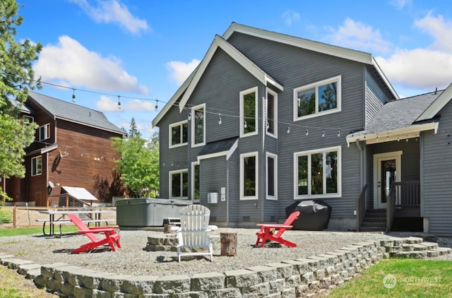 rear view of house with a hot tub