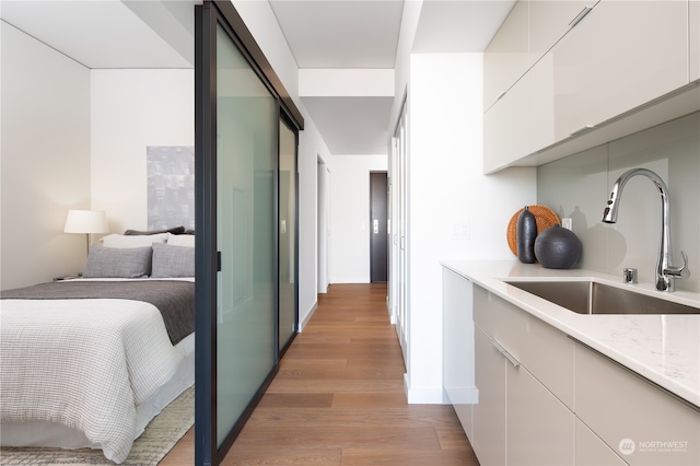 kitchen featuring white cabinetry, light hardwood / wood-style flooring, and sink