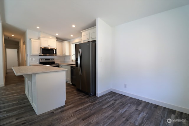 kitchen with white cabinetry, stainless steel appliances, a center island, and dark hardwood / wood-style floors