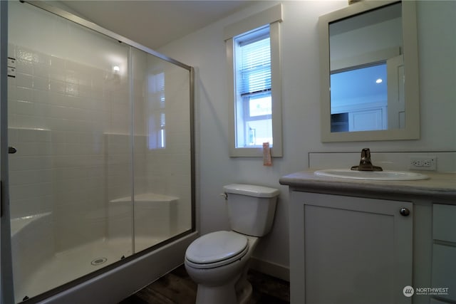 bathroom with vanity, hardwood / wood-style flooring, toilet, and walk in shower