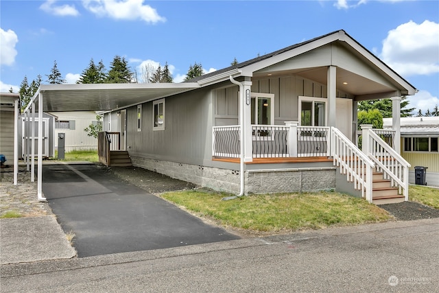 manufactured / mobile home with a carport, a storage unit, and a porch