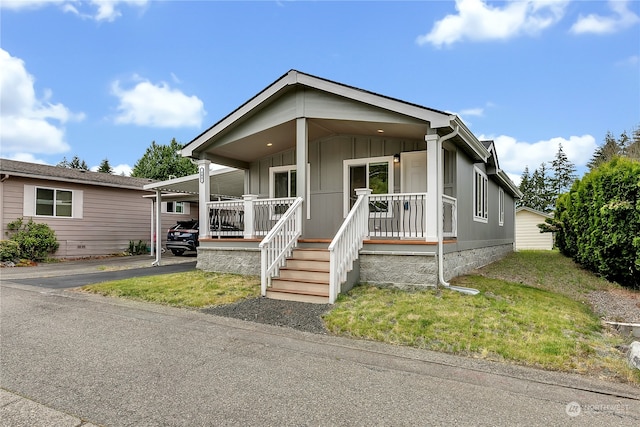 manufactured / mobile home with a front yard and a porch