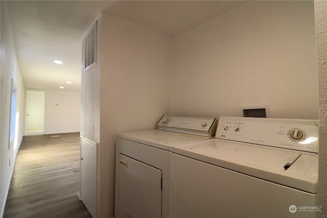 washroom with hardwood / wood-style flooring and independent washer and dryer