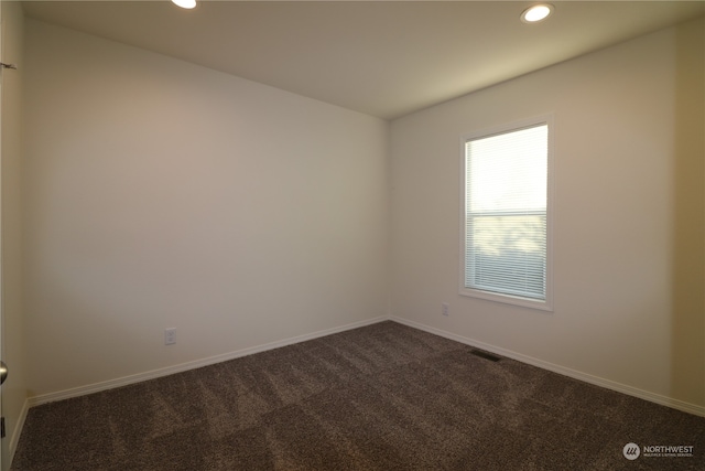 empty room featuring dark carpet