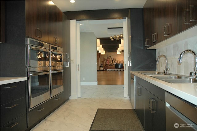 kitchen with stainless steel appliances, dark brown cabinets, sink, and decorative backsplash