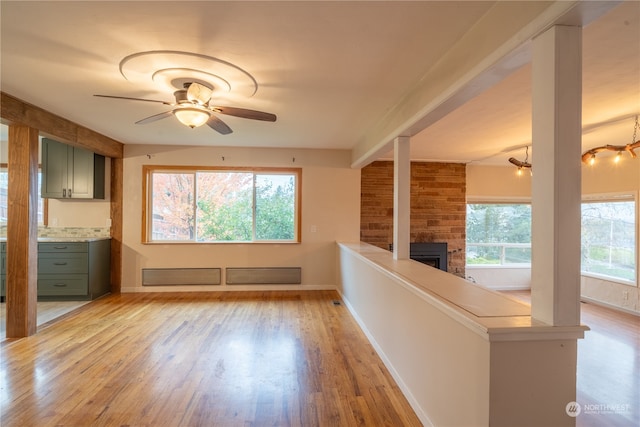 interior space with light hardwood / wood-style floors, ceiling fan, and a large fireplace