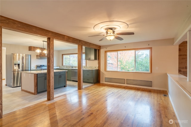 unfurnished living room with light hardwood / wood-style flooring, ceiling fan, and sink