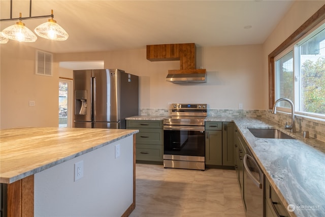 kitchen featuring stainless steel appliances, sink, light stone counters, tasteful backsplash, and hanging light fixtures