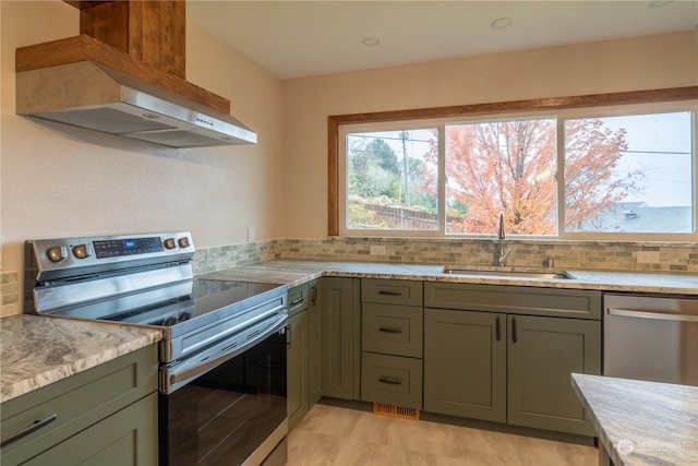 kitchen with decorative backsplash, wall chimney range hood, appliances with stainless steel finishes, and sink