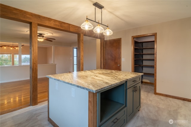 kitchen with light wood-type flooring, decorative light fixtures, a healthy amount of sunlight, and a center island