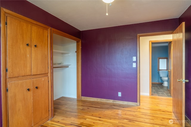 unfurnished bedroom featuring a closet and light wood-type flooring