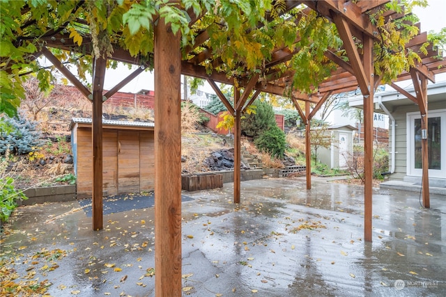 view of patio / terrace with a pergola and a storage shed