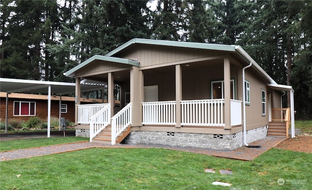 view of front facade featuring a front yard, a carport, and a porch