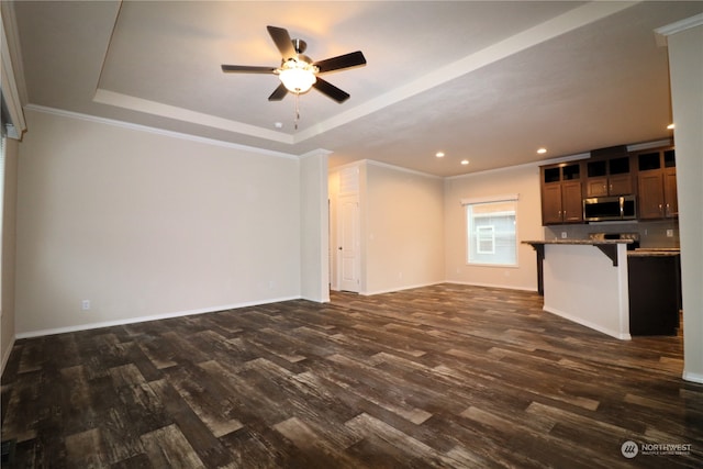 unfurnished living room featuring ornamental molding, dark hardwood / wood-style floors, a tray ceiling, and ceiling fan