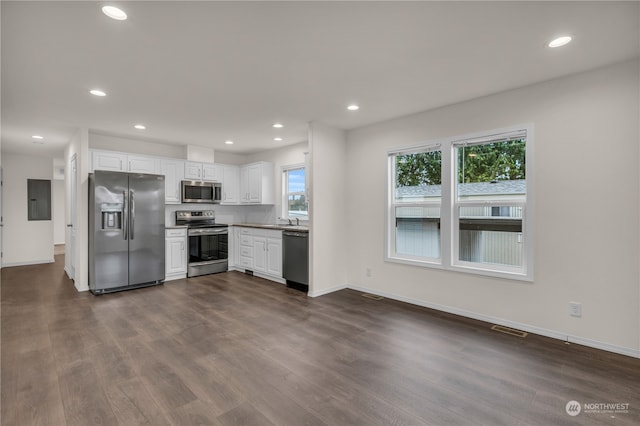 kitchen featuring appliances with stainless steel finishes, white cabinets, electric panel, and dark wood-type flooring