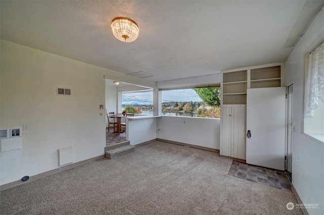 spare room with carpet and a textured ceiling