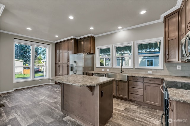 kitchen with a center island, hardwood / wood-style floors, stainless steel appliances, and sink