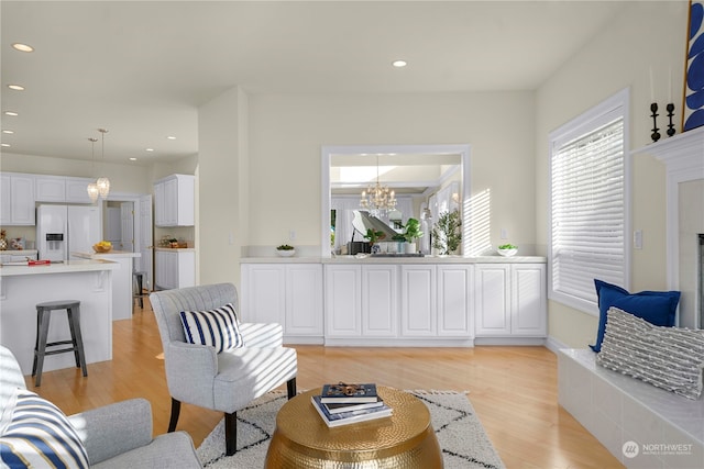 living room with an inviting chandelier and light hardwood / wood-style floors