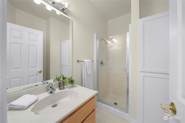 bathroom featuring vanity, a shower with shower door, and tile patterned flooring