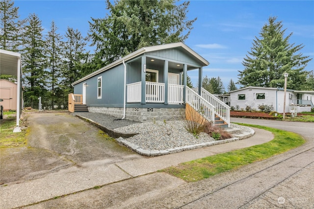 manufactured / mobile home with a shed and covered porch