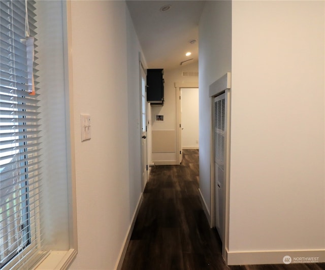 hall with vaulted ceiling and dark hardwood / wood-style flooring