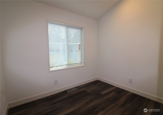 empty room with dark wood-type flooring and vaulted ceiling