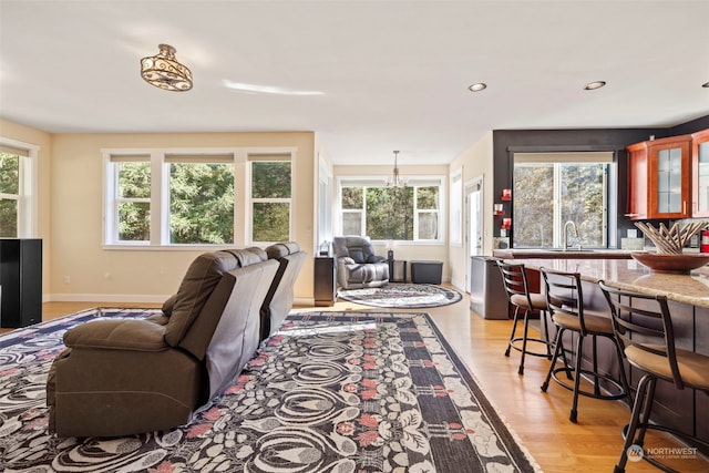 living area featuring light wood finished floors, baseboards, and recessed lighting