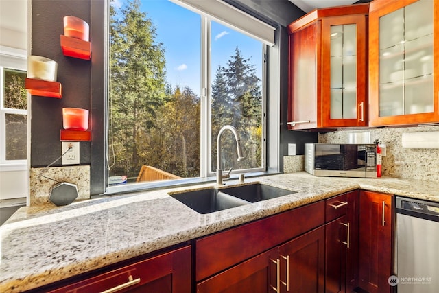 kitchen featuring a wealth of natural light, appliances with stainless steel finishes, backsplash, and a sink