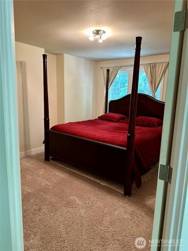 carpeted bedroom with a textured ceiling and baseboards