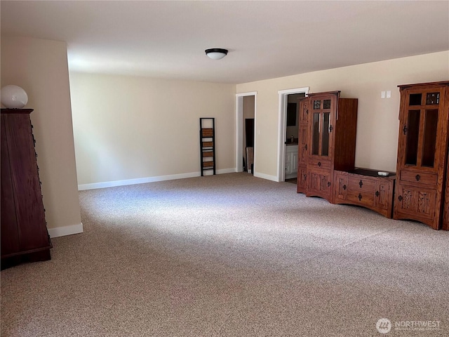 carpeted spare room featuring baseboards