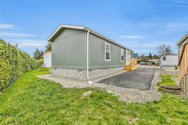 view of side of home featuring a patio and a lawn