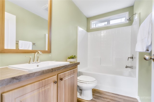 full bathroom featuring shower / bath combination, lofted ceiling, toilet, hardwood / wood-style flooring, and vanity