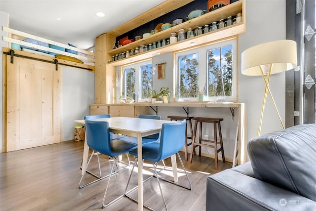 dining room featuring a barn door and hardwood / wood-style flooring